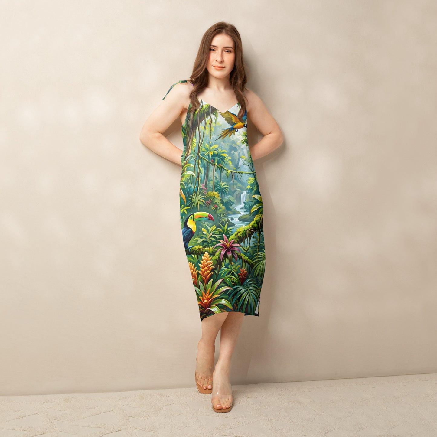 Female model wearing the Rainforest Reverie midi dress with a vibrant tropical rainforest print featuring a toucan, macaw, and lush greenery, styled with tie shoulder straps