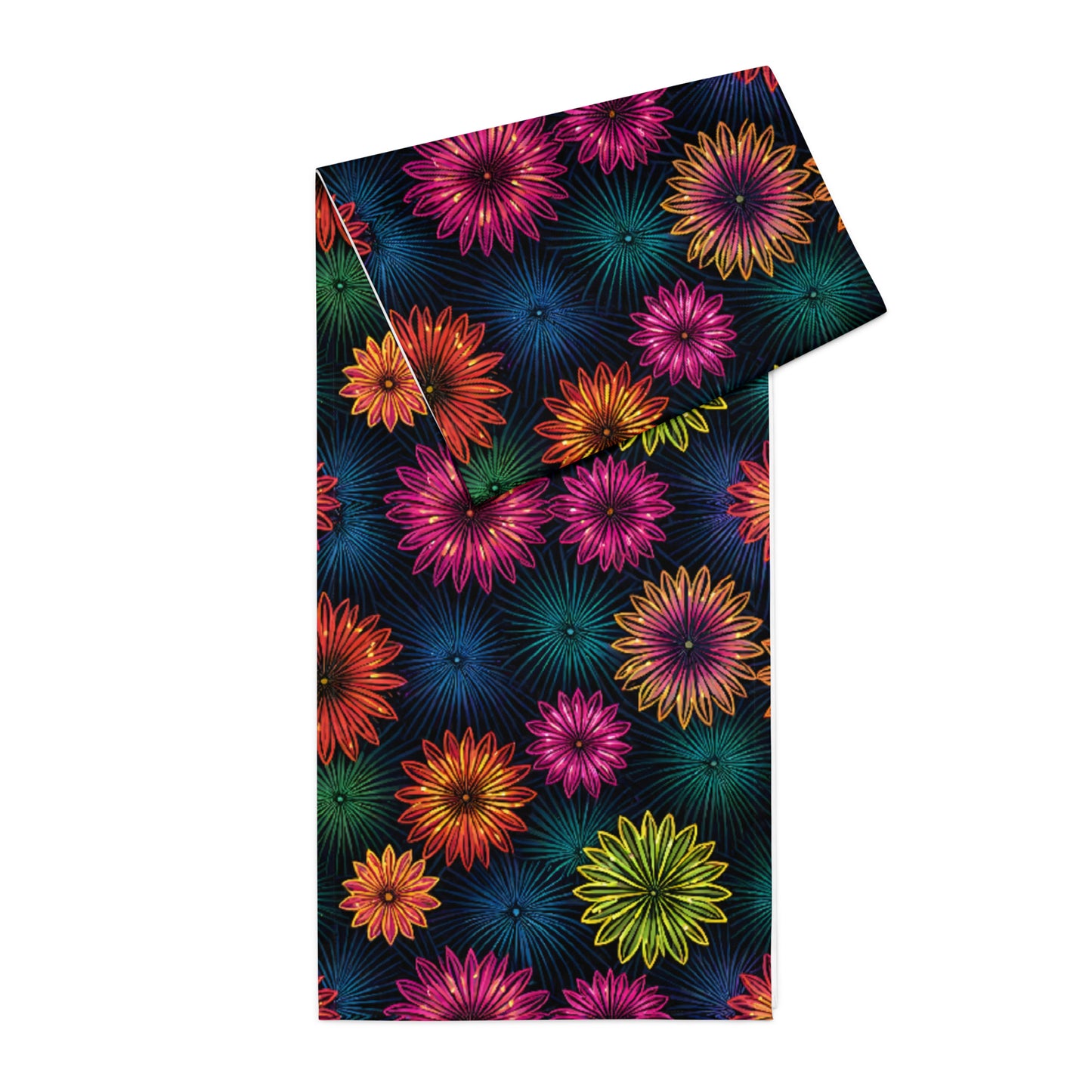 Fluorescent Floral Table Runner product shot — table runner partially rolled showing white reverse side rolled up and all-over print of neon pink orange yellow-green and teal daisy-like flowers with radiating petal details on dark navy background on white background